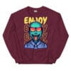 A colorful unisex sweatshirt featuring a vibrant alien wearing sunglasses with a playful expression, set against a bold yellow "ENJOY" text design